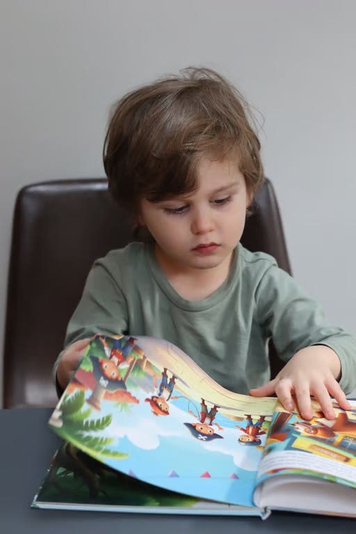 A child looking at an illustrated book spread